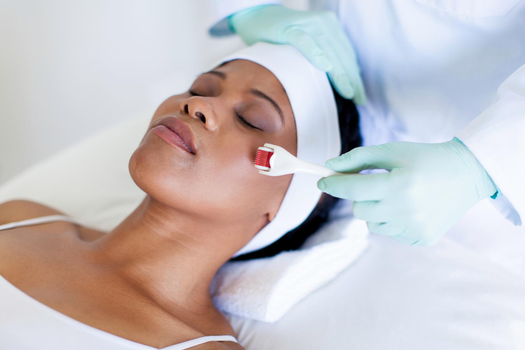 African patient getting micro-needling treatment by her doctor